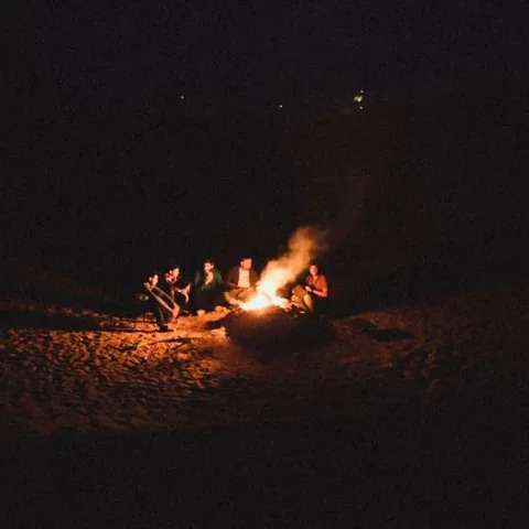 A small fire beneath a dark night sky